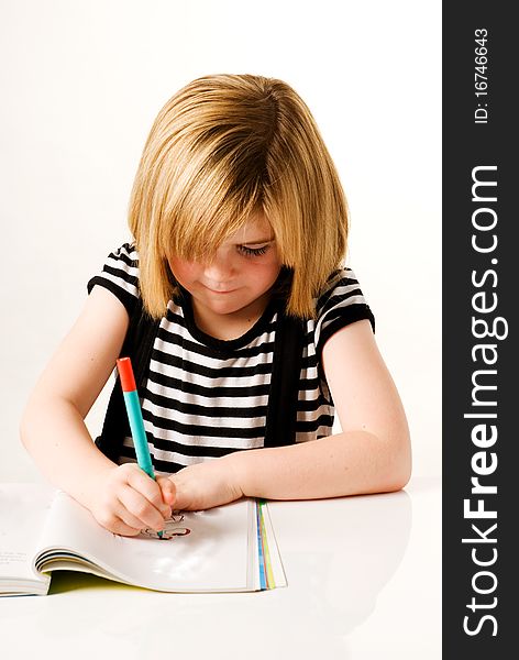 A vertical image of a young girl drawing in her colouring book. A vertical image of a young girl drawing in her colouring book
