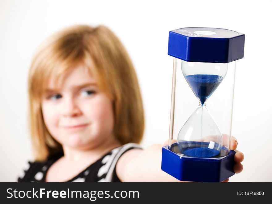 A horizontal image of a young girl holding out a hourglass. A horizontal image of a young girl holding out a hourglass