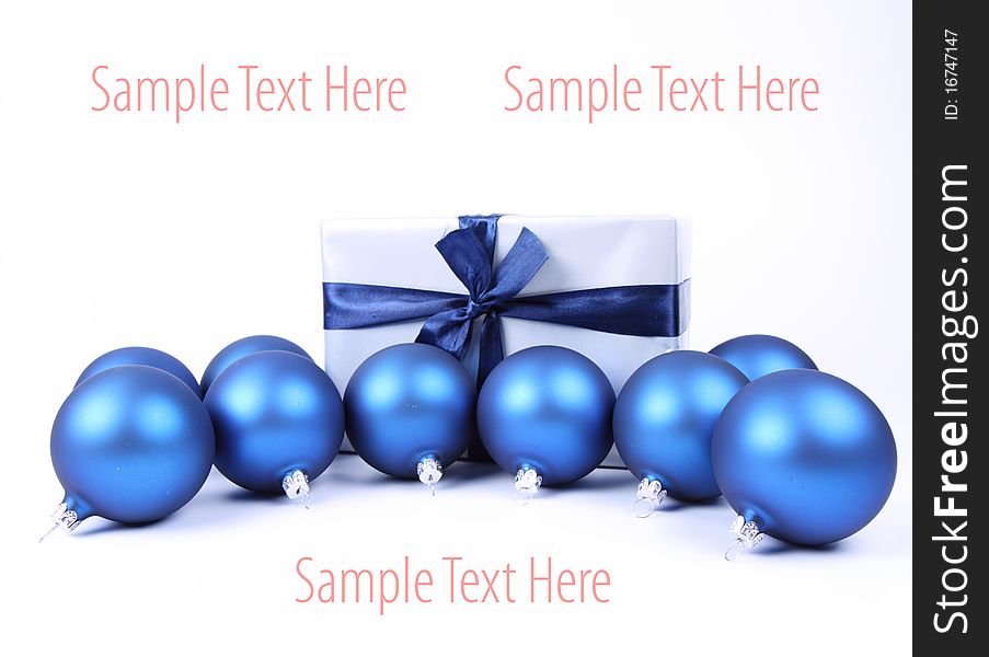 Blue matt christmas balls and a gift in red wrapping on white background, with space for your text. Blue matt christmas balls and a gift in red wrapping on white background, with space for your text