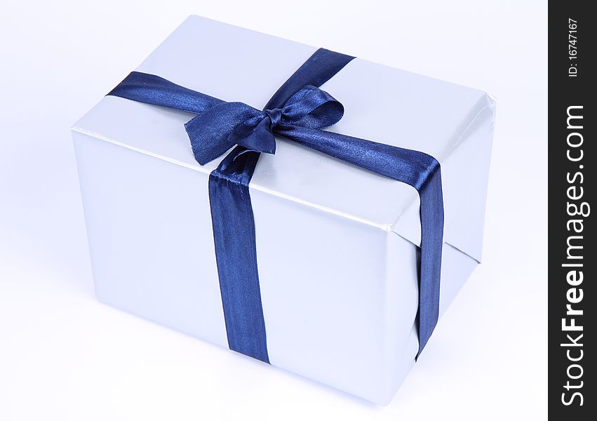 Gift in silver wrapping with a blue bow on white background