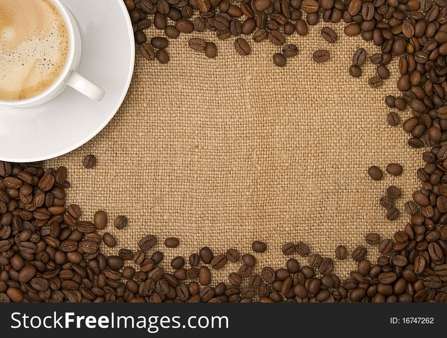 Burlap, canvas as a backdrop, coffee beans as a frame, and a cup of coffee