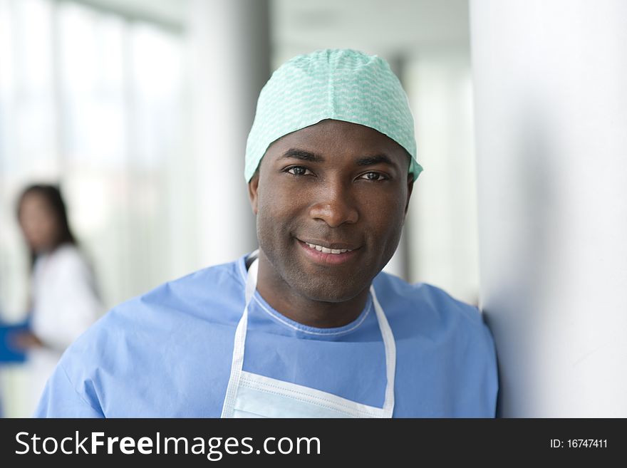 Portrait of a male surgeon, colleagues on background