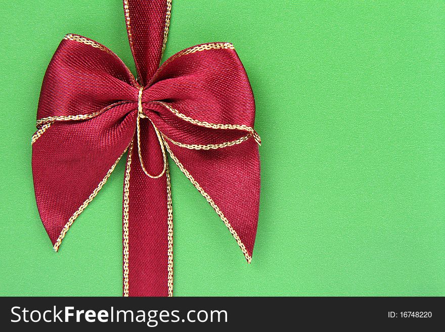 Gift in green wrapping with a red bow in close up. Gift in green wrapping with a red bow in close up