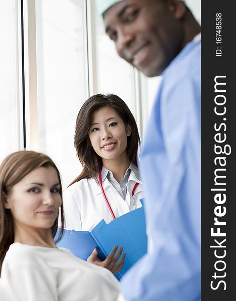 Doctor and surgeon speaking with a female patient. Doctor and surgeon speaking with a female patient