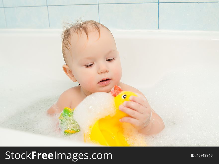 Cute adorable baby play with toy sitting in foam bath. Cute adorable baby play with toy sitting in foam bath