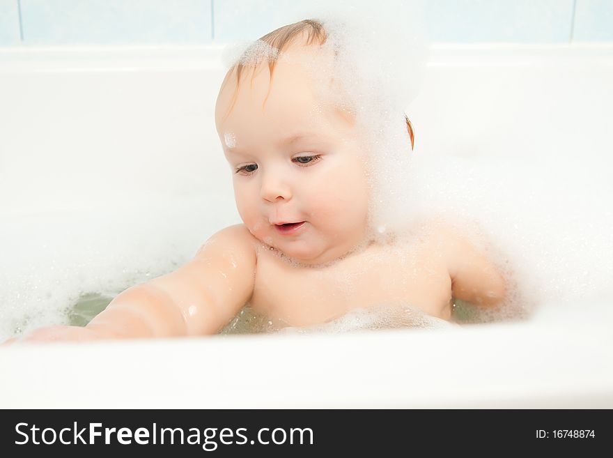 Cute adorable baby clapping on water in foam bath. Cute adorable baby clapping on water in foam bath