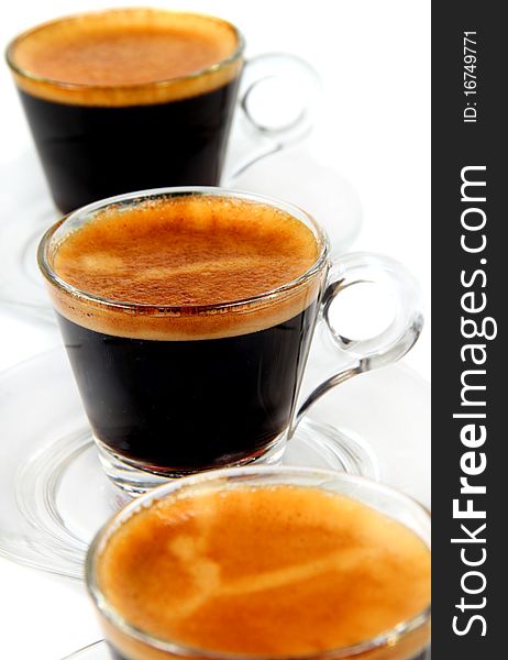 Espresso in the  transparent cups on the white background. Espresso in the  transparent cups on the white background