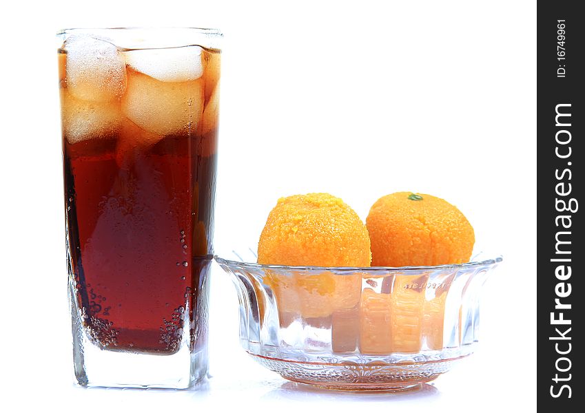 Orange and cola drink glasses with indian sweets isolated on white background. Orange and cola drink glasses with indian sweets isolated on white background.