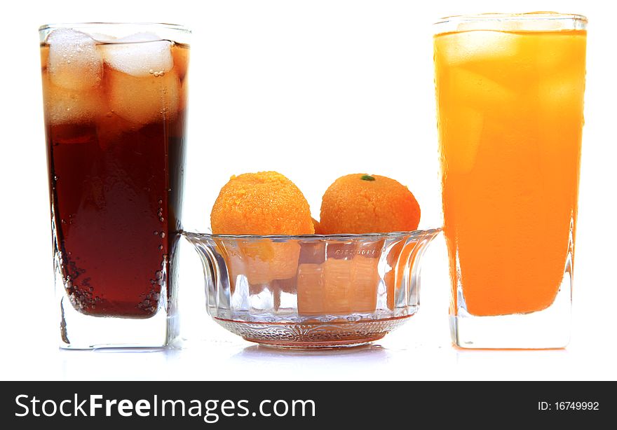 Orange and cola drink glasses with sweets isolated on white background. Orange and cola drink glasses with sweets isolated on white background.