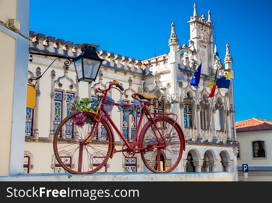 Old decorated bicycle and Sintra Town Hall building on background in a beautiful sunny day