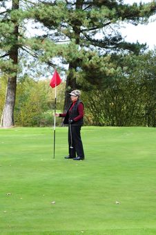 Female Golfer Holding Putting Flag Royalty Free Stock Images