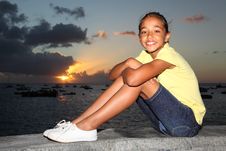 Young School Girl Sitting By The Seaside At Sunset Stock Image