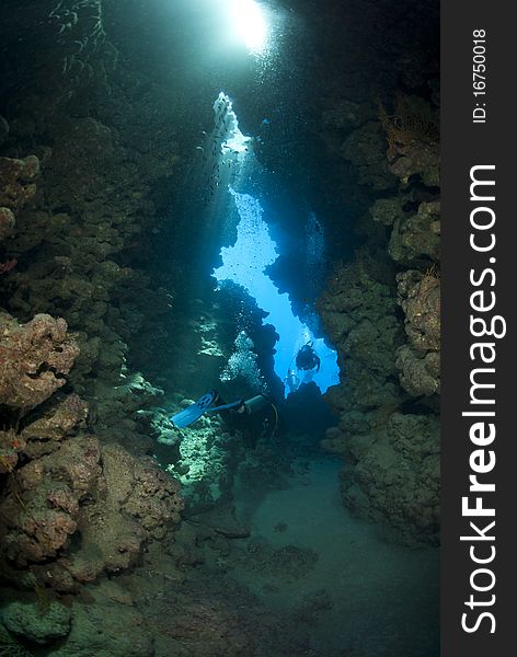 Scuba divers inside an underwater cave.