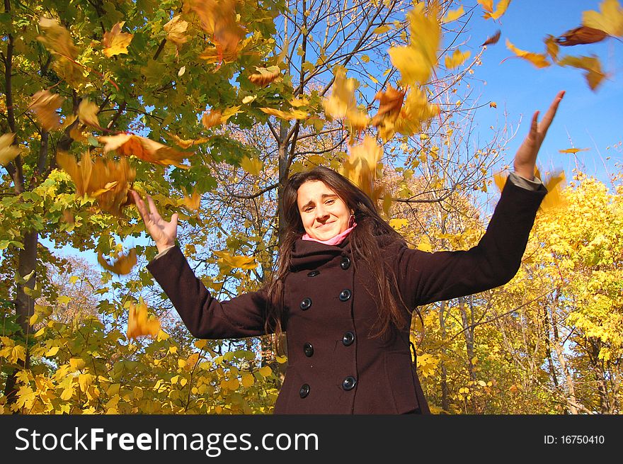 Girl and falling leaves in the autumn