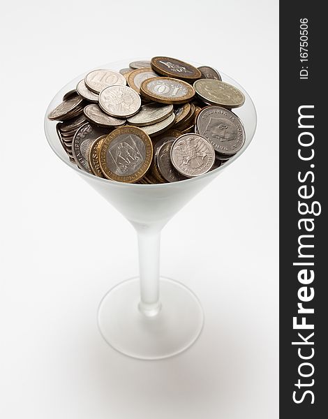 Foreign coins lie in a glass
