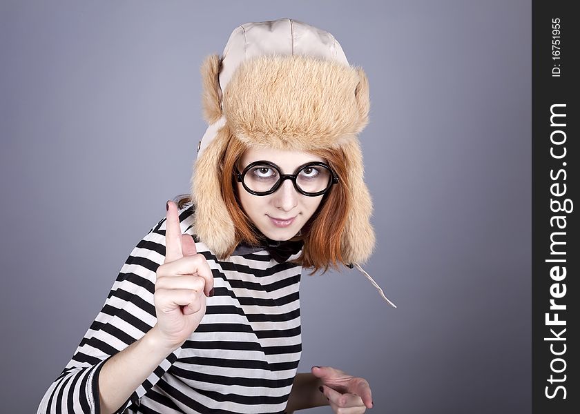 Funny girl in winter cap and glasses. Studio shot.