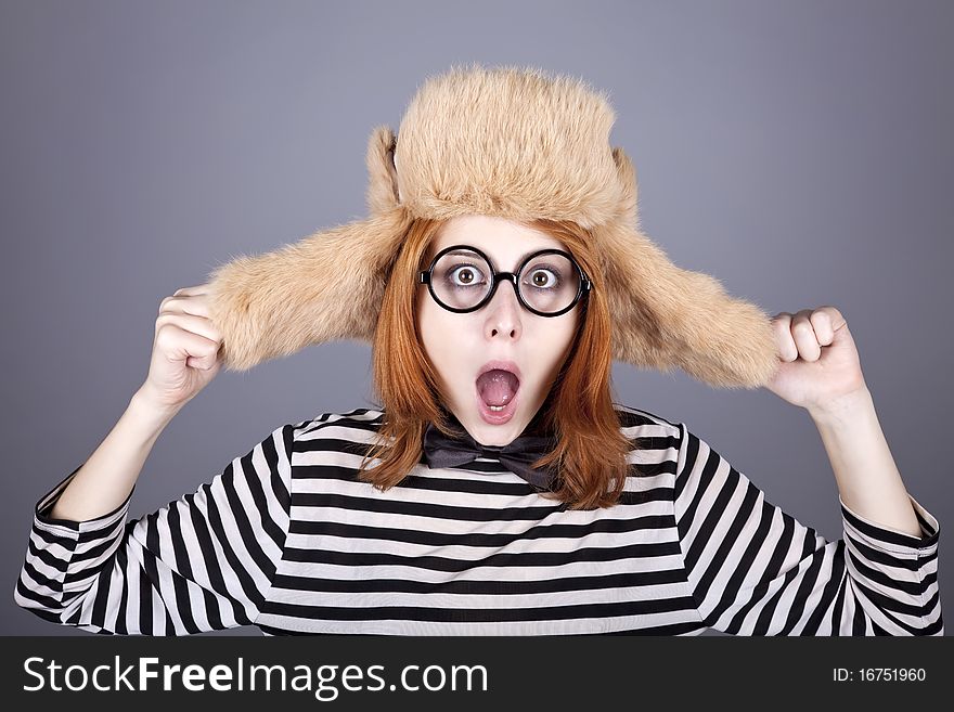 Funny girl in winter cap and glasses. Studio shot.