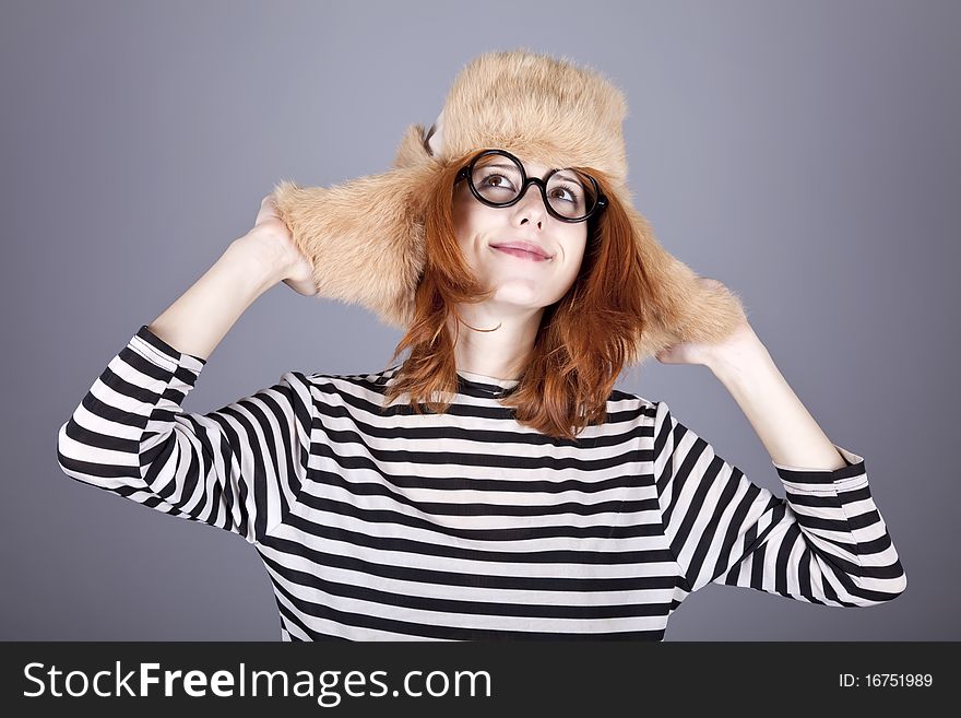 Funny girl in winter cap and glasses. Studio shot.