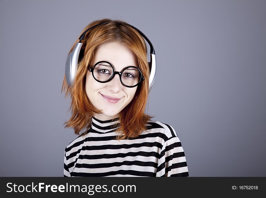 Funny girl with headphone and glasses. Studio shot.