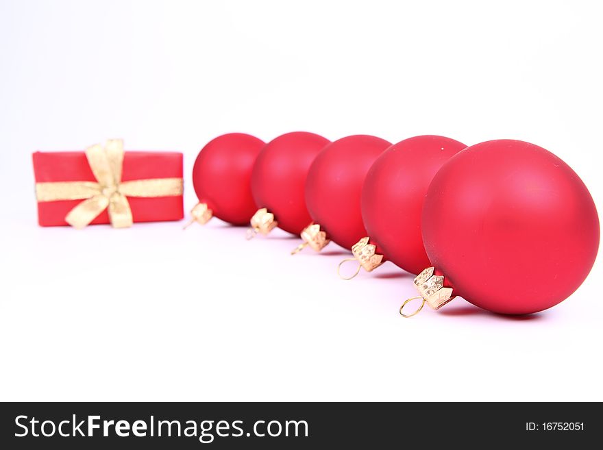 Red matt christmas balls and a gift in red wrapping on white background, with space for your text. Red matt christmas balls and a gift in red wrapping on white background, with space for your text