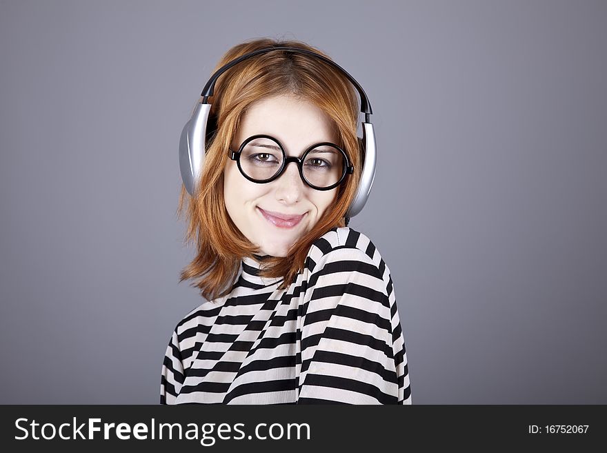 Funny girl with headphone and glasses. Studio shot.