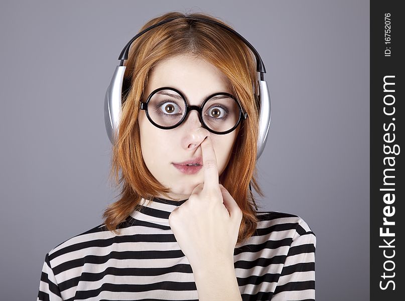 Funny girl with headphone and glasses. Studio shot.