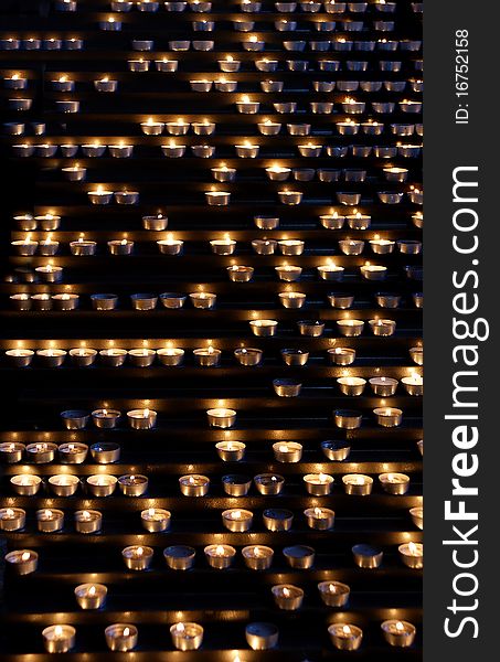 Background of burning candles in a church.