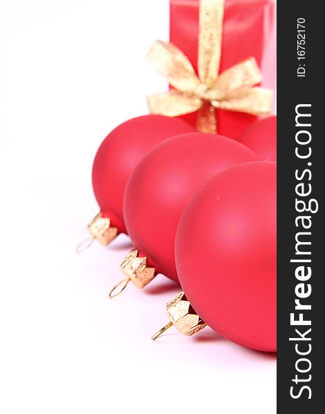 Red matt christmas balls and a gift in red wrapping on white background, with space for your text. Red matt christmas balls and a gift in red wrapping on white background, with space for your text
