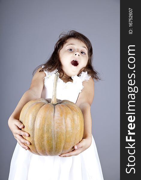 Funny Little Girl In Dress Keeping Pumpkin.