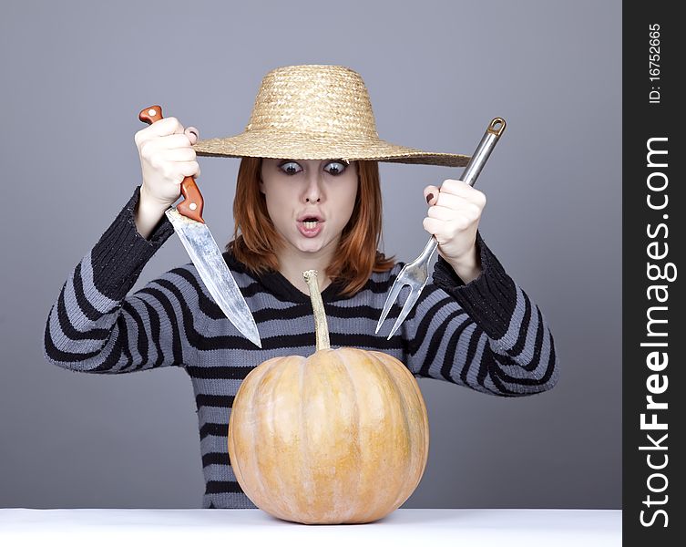 Funny girl in cap and fork with knife try to eat a pumpkin. Studio shot. Funny girl in cap and fork with knife try to eat a pumpkin. Studio shot.