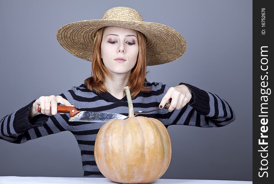 Funny girl in cap and fork with knife try to eat a pumpkin. Studio shot. Funny girl in cap and fork with knife try to eat a pumpkin. Studio shot.