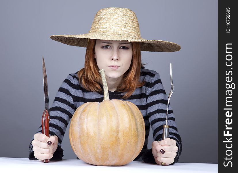 Funny girl in cap and fork with knife try to eat a pumpkin. Studio shot. Funny girl in cap and fork with knife try to eat a pumpkin. Studio shot.