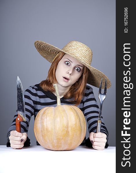 Funny girl in cap and fork with knife try to eat a pumpkin. Studio shot. Funny girl in cap and fork with knife try to eat a pumpkin. Studio shot.