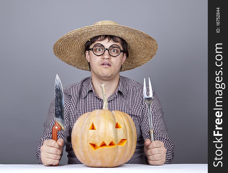 Funny men try to eat a pumpkin. Studio shot.