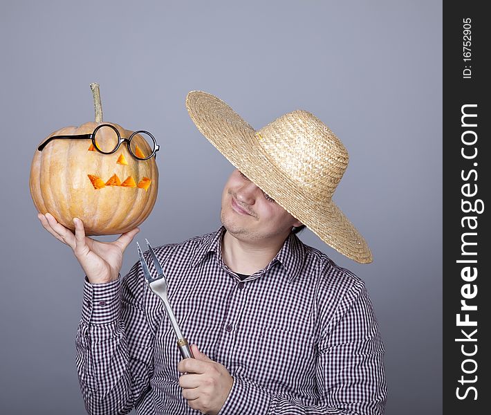 Funny men try to eat a pumpkin. Studio shot.