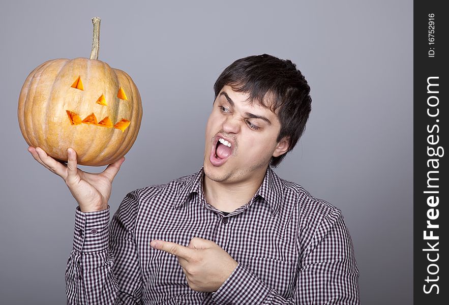 Funny men showing a pumpkin. Studio shot.