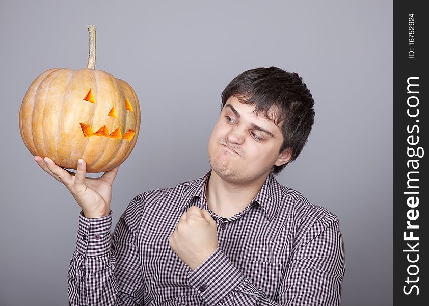 Funny men showing a pumpkin. Studio shot.