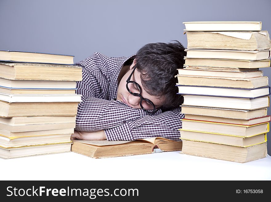 The young tired student with the books isolated. Studio shot.