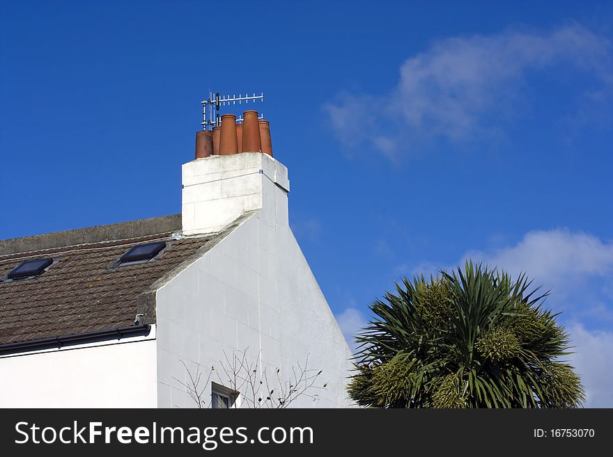 Old fashioned chimneys against clouds and a bright blue sky. Old fashioned chimneys against clouds and a bright blue sky