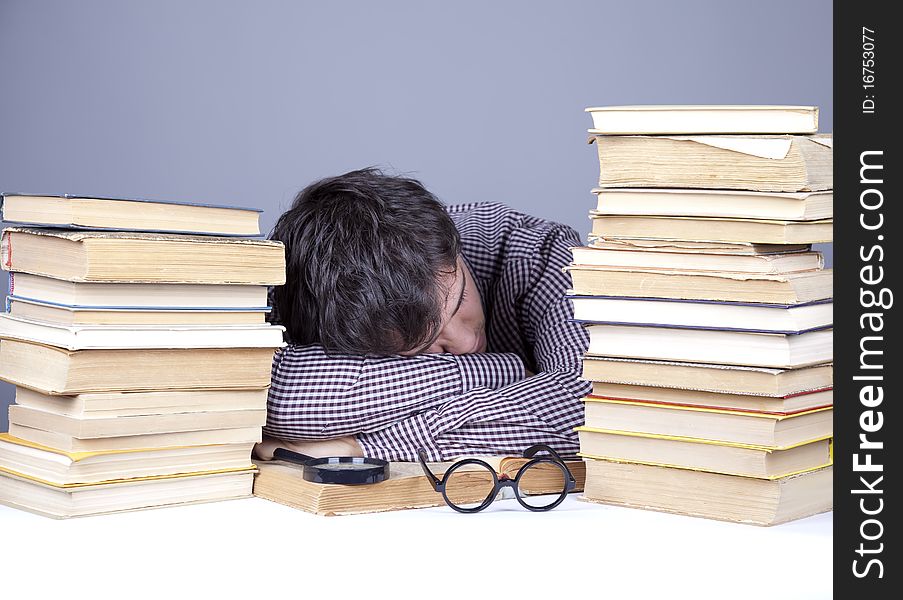 The young tired student with the books isolated. Studio shot.