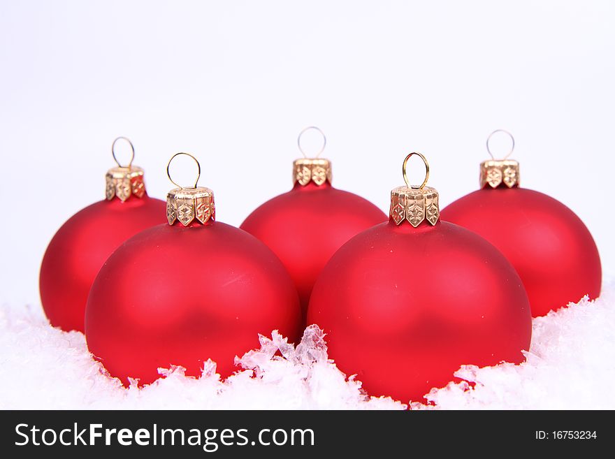 Red matt christmas balls on snow on white background, with space for your text. Red matt christmas balls on snow on white background, with space for your text