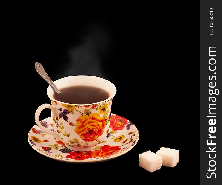 A Cup Of Hot Tea With A Sugar Isolated On Black
