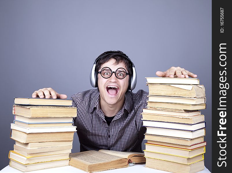 The young student with the books and headphone isolated. Studio shot.