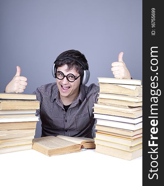 The young student with the books and headphone isolated. Studio shot.