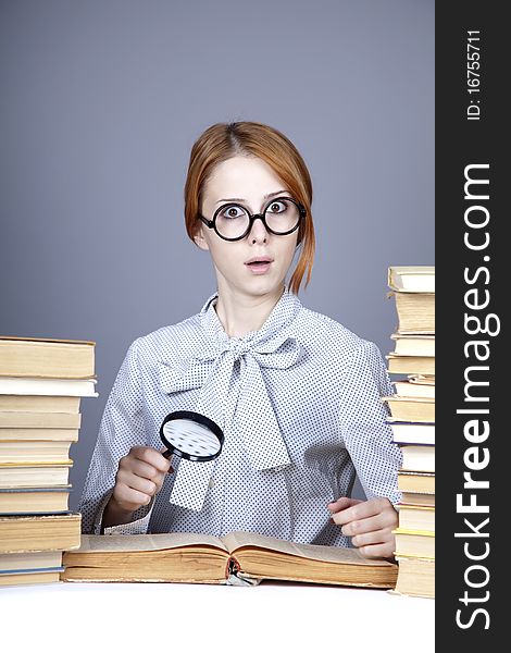 The young teacher in glasses with books.