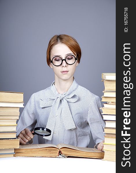 The young teacher in glasses with books. Studio shot.