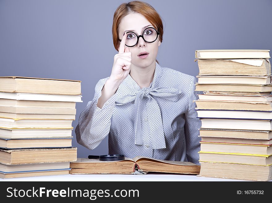 The young teacher in glasses with books. Studio shot.