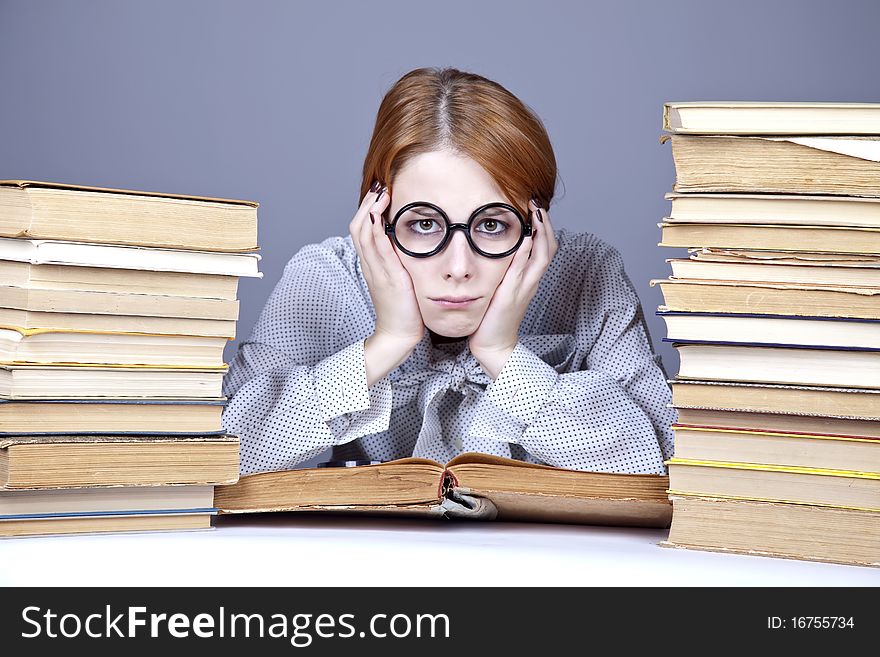 The young teacher in glasses with books. Studio shot.