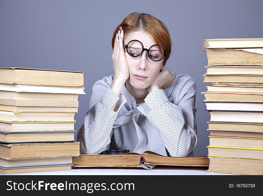 The young teacher in glasses with books. Studio shot.