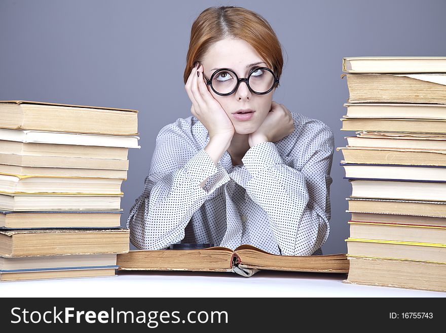 The young teacher in glasses with books. Studio shot.